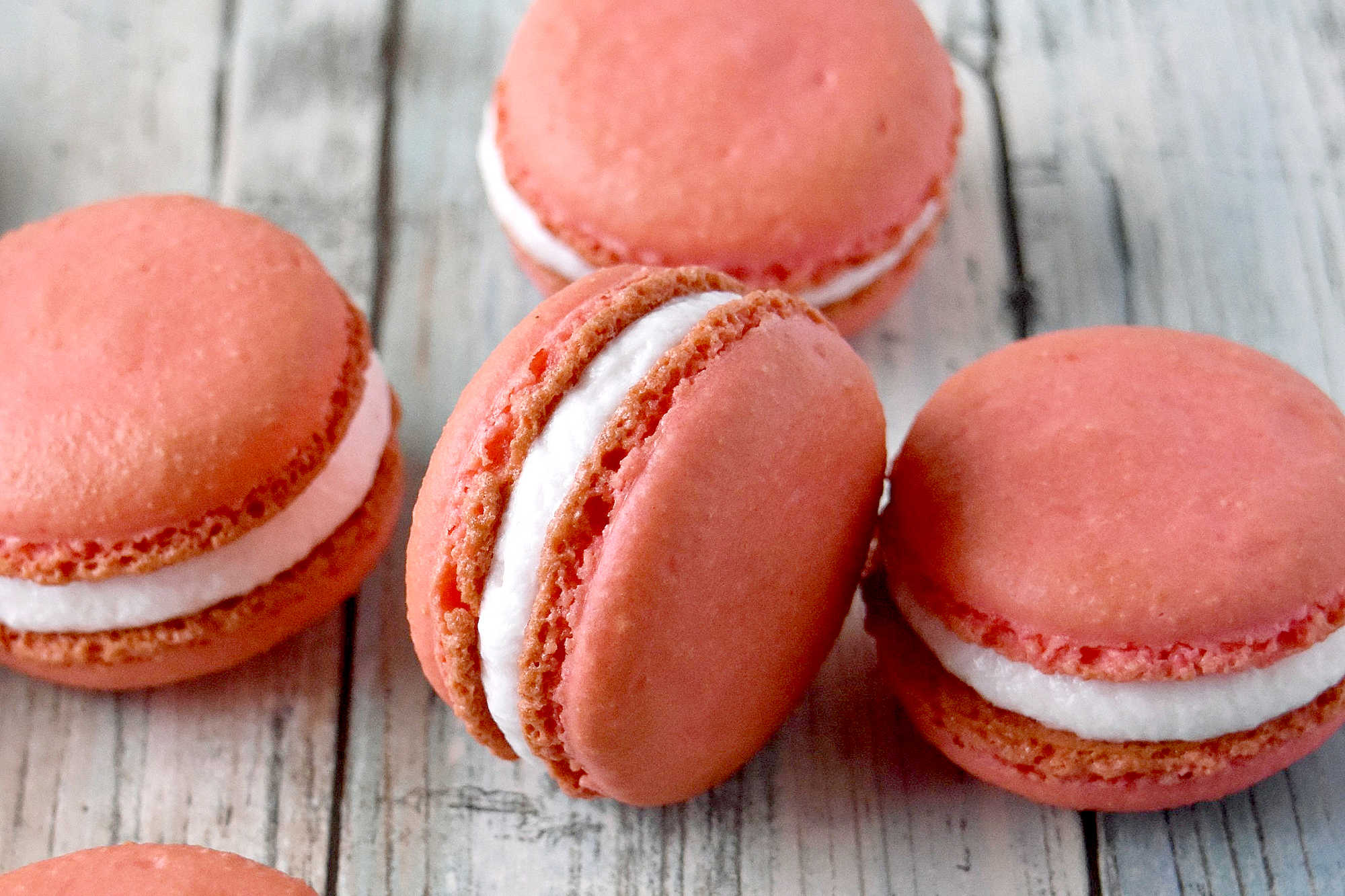 Peach macarons are the sweetest little summer bake. These use freeze-dried peaches in the shells and peach syrup in the filling for bright, fruity flavor in every bite. Perfect for a beginner-friendly showstopper! #peachmacarons #macarons #frenchmacarons #macaronlove #peachdessert #summerdesserts #prettybakes #bakingfromscratch #homebaker #desserttable #teapartyideas #bridalshowerdesserts #Stonefruit