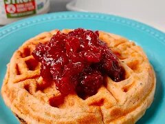 Sweet potato waffles are warmly spiced and topped with a tart cranberry orange sauce for a seasonal breakfast or brunch.