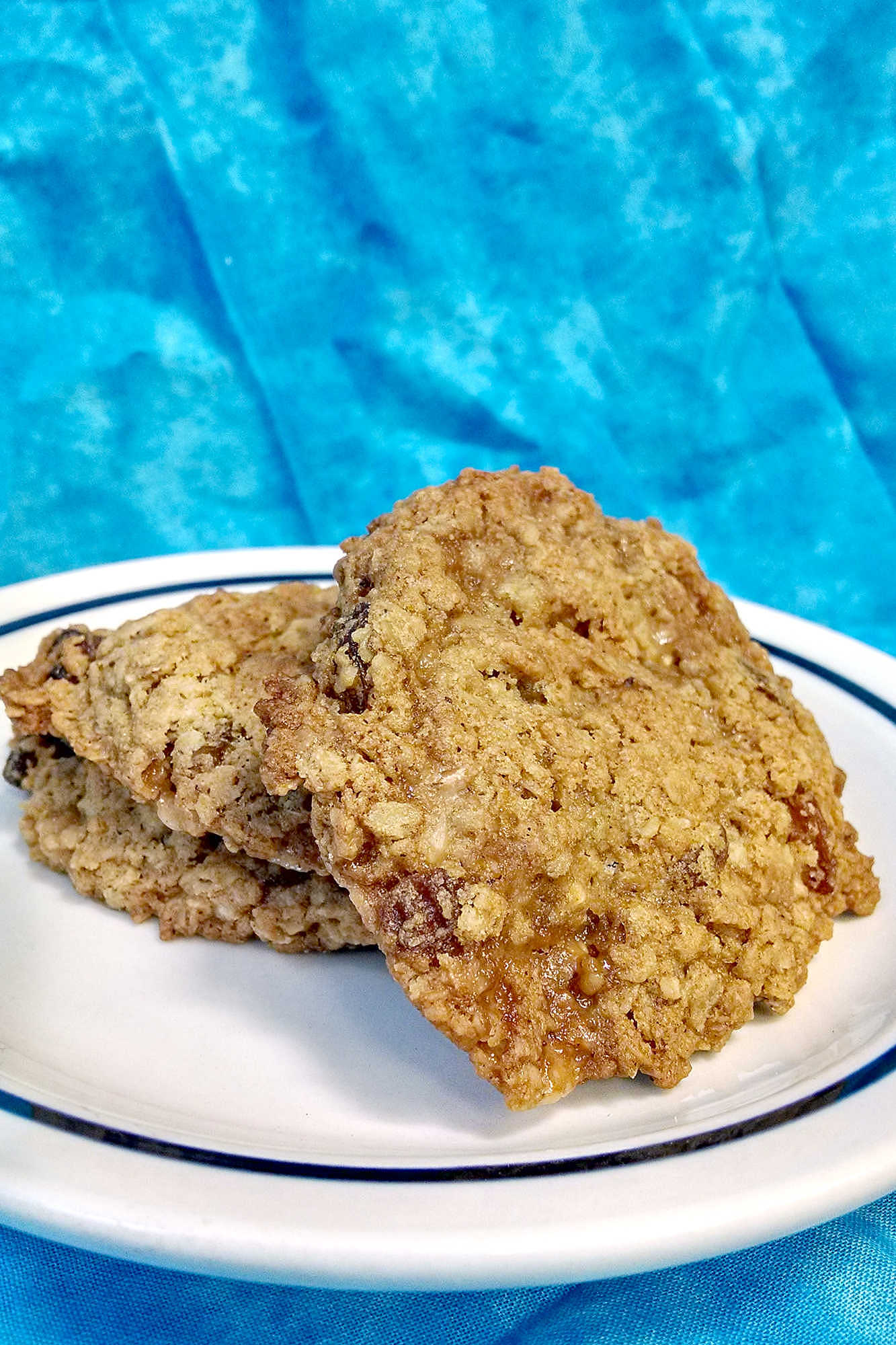 Classic oatmeal raisin cookies meet buttery candy-shop crunch in this chewy toffee cookie recipe. These Oatmeal Raisin Toffe Cookies are cozy enough for fall baking and fun enough for a cookie tray.  #OatmealCookies #RaisinCookies #ToffeeCookies #CookieRecipe #HolidayBaking #OurFamilyTable