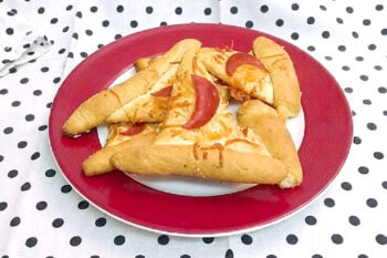 A little crooked, wonderfully cheesy, and ready for the Halloween party! These golden crescent Witch Hats hide pepperoni beneath crisp Parmesan and herbs. #witchhats #halloweenfood #halloweensnacks #easyhalloweenideas #spookyseason #halloweenpartyfood #halloweenrecipes #kidfriendlyfood #hocuspocus #allhallowseve